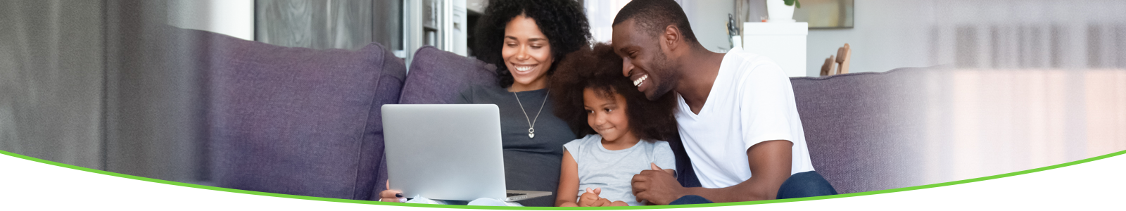 Family sitting on couch looking at laptop